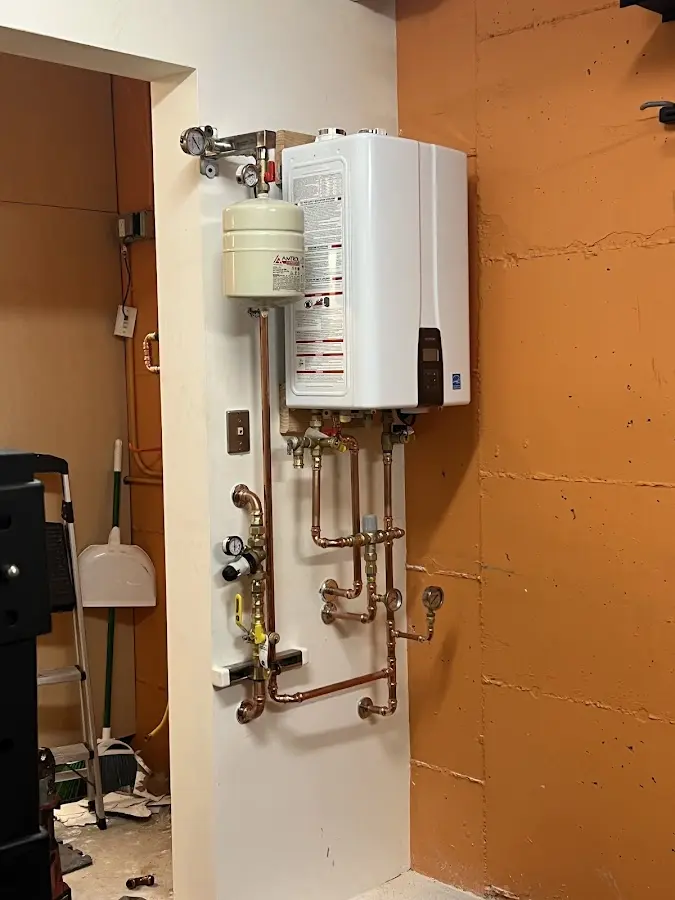 Plumbing technician inspecting water heater connections in Biloxi